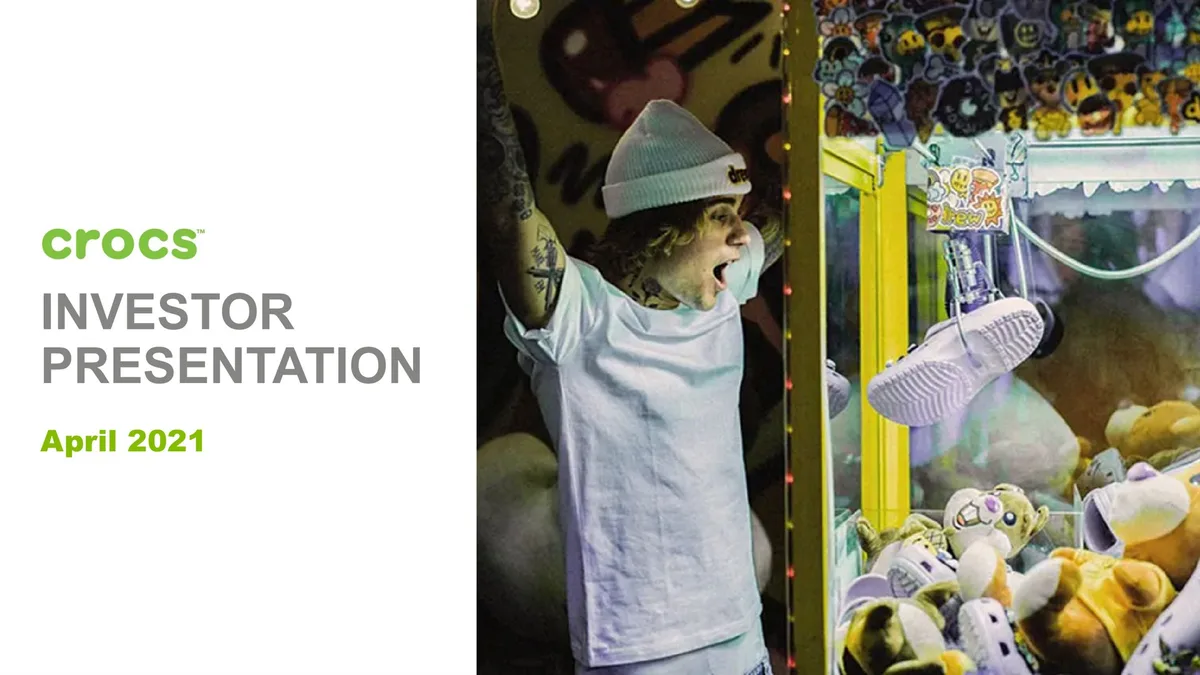The image features Justin Bieber (drew house brand) interacting with a claw machine containing Crocs, highlighting brand collaboration.