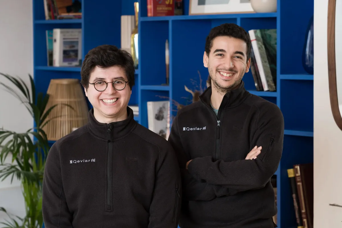This is a team slide featuring the two founders wearing branded apparel.