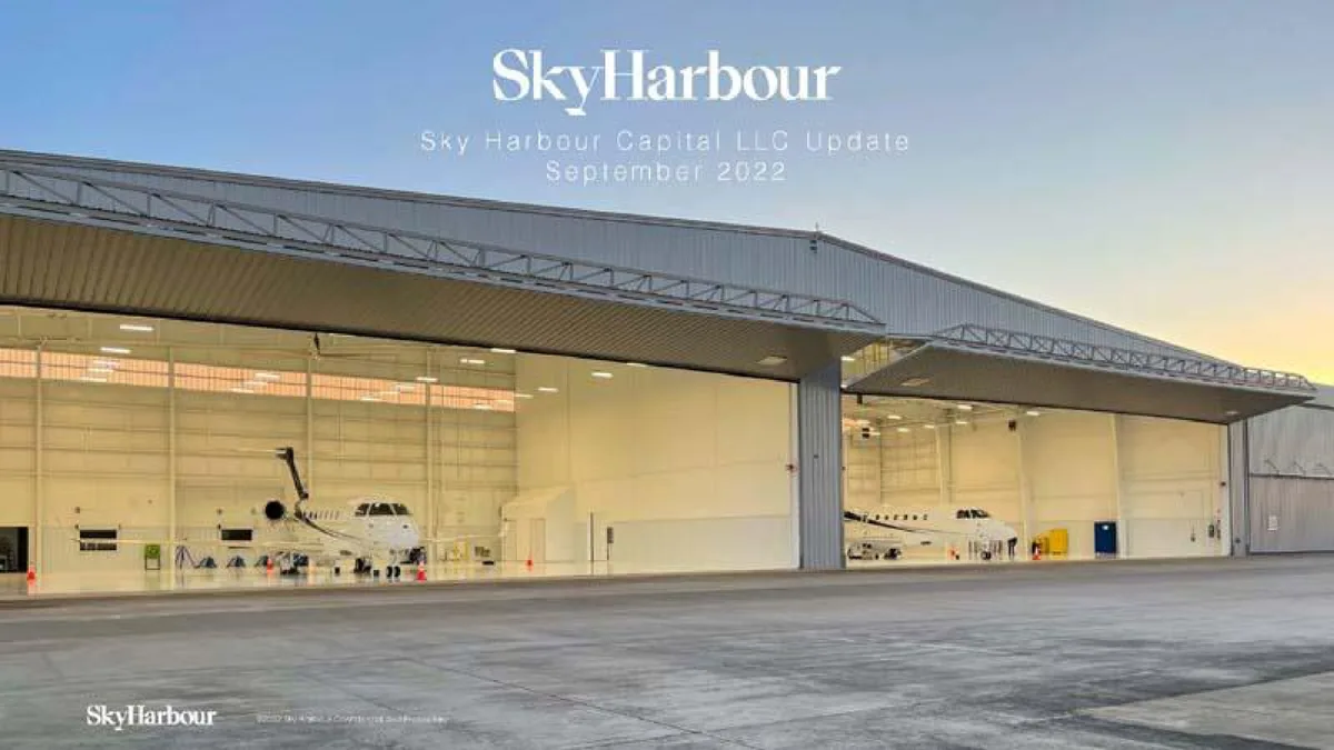 The slide features a high-quality photograph of an aircraft hangar facility.