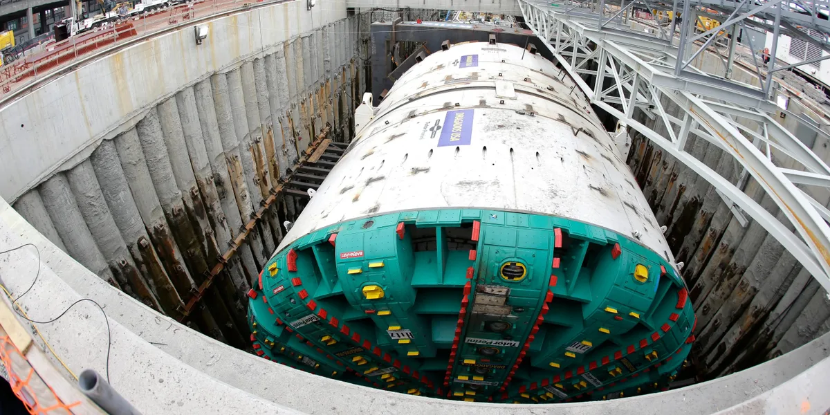 The image features branding for 'Dragados USA' and 'Tutor Perini' on the TBM cutterhead.